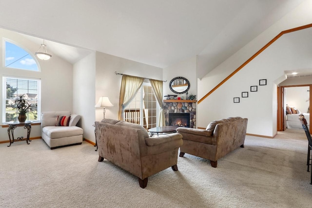 living room featuring a fireplace, high vaulted ceiling, and light colored carpet