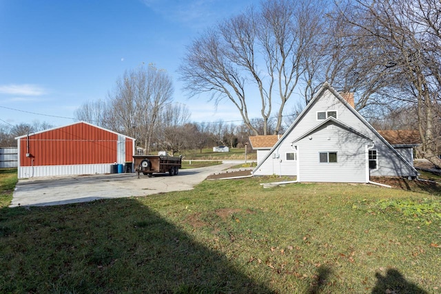 view of side of home featuring a lawn and an outdoor structure