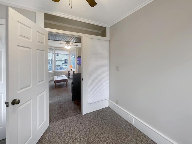 hallway featuring dark colored carpet and ornamental molding