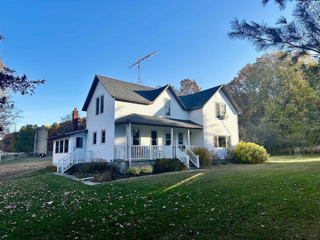 view of property with a porch and a front lawn