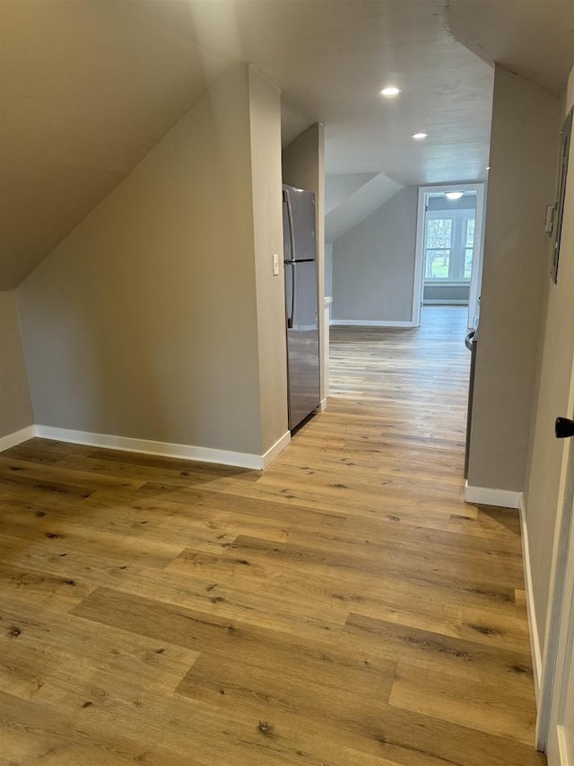 additional living space featuring baseboards, recessed lighting, lofted ceiling, and light wood-style floors