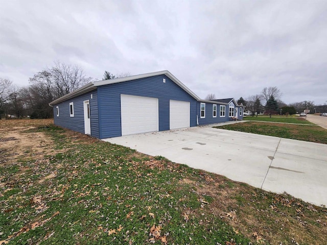 view of side of property featuring a garage and a yard