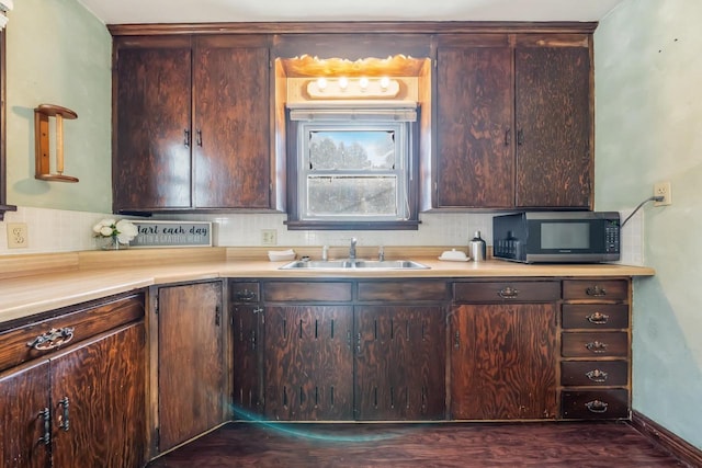 kitchen featuring dark brown cabinets, tasteful backsplash, dark wood-type flooring, and sink