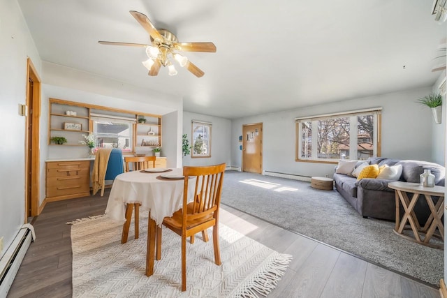 dining space with wood-type flooring, a baseboard radiator, and ceiling fan