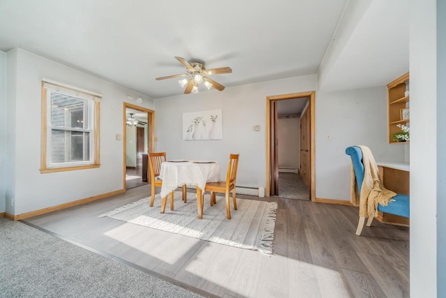 dining room featuring baseboard heating, ceiling fan, and light hardwood / wood-style floors