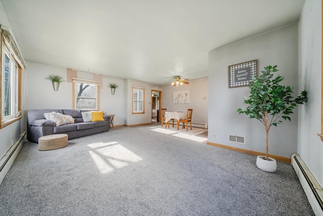 living room with baseboard heating, ceiling fan, and carpet