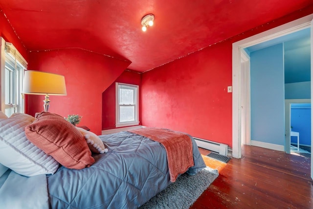 bedroom featuring dark hardwood / wood-style floors, vaulted ceiling, and baseboard heating