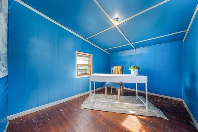 home office with hardwood / wood-style floors, lofted ceiling, and wood walls