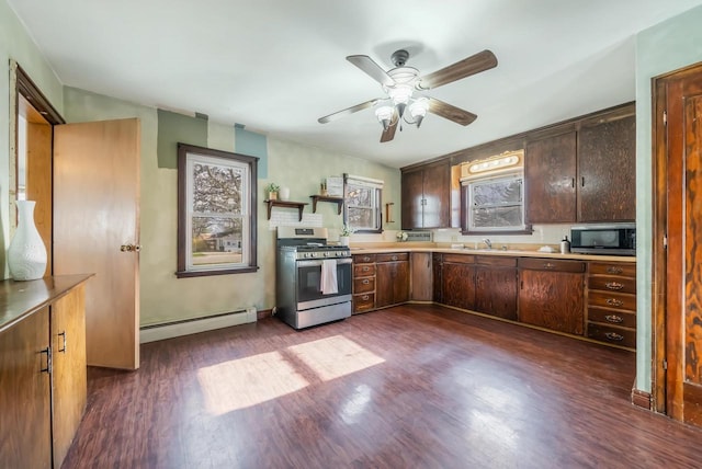 kitchen with ceiling fan, sink, stainless steel appliances, dark hardwood / wood-style flooring, and a baseboard heating unit