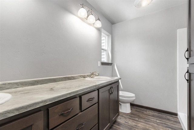 bathroom featuring wood-type flooring, vanity, and toilet