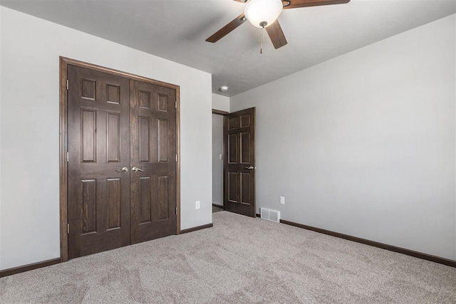 unfurnished bedroom featuring carpet, a closet, and ceiling fan