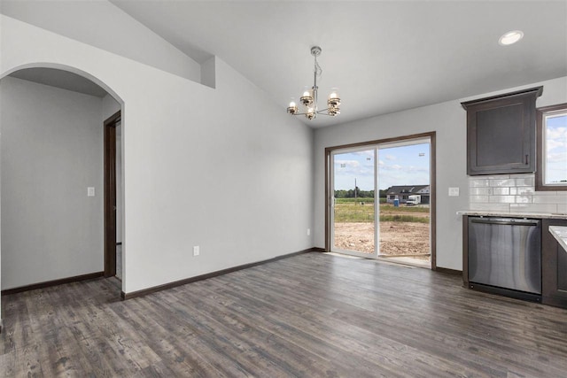 unfurnished dining area featuring dark wood-type flooring, a wealth of natural light, and vaulted ceiling