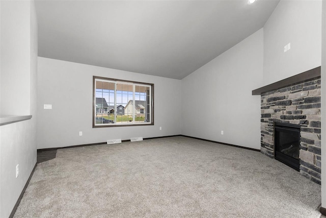 unfurnished living room with light carpet, vaulted ceiling, and a fireplace