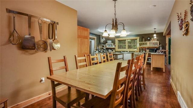 dining area featuring dark hardwood / wood-style floors and an inviting chandelier