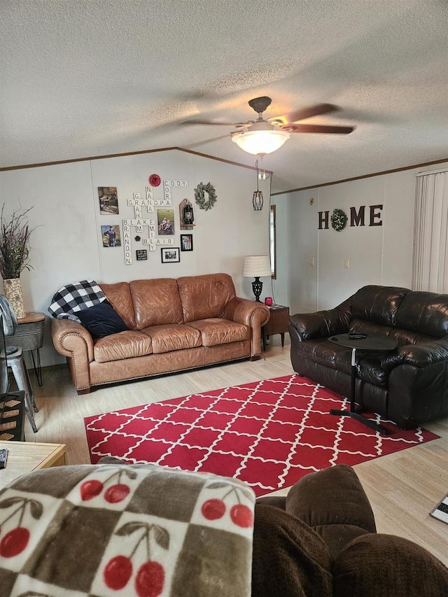 living room featuring hardwood / wood-style floors, ceiling fan, and a textured ceiling