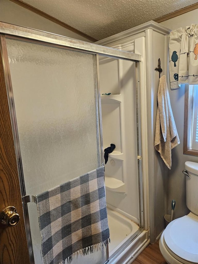 bathroom featuring hardwood / wood-style floors, a shower with shower door, lofted ceiling, and a textured ceiling