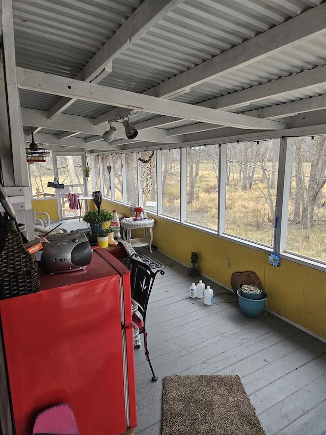 sunroom with beam ceiling and a healthy amount of sunlight