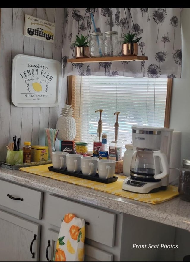 kitchen featuring white cabinets and wooden walls