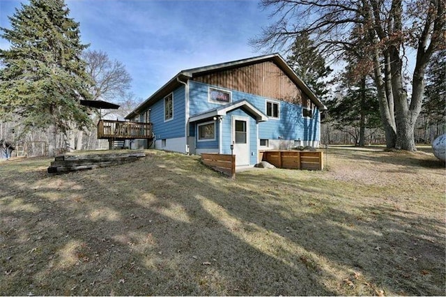 back of house with a lawn and a wooden deck