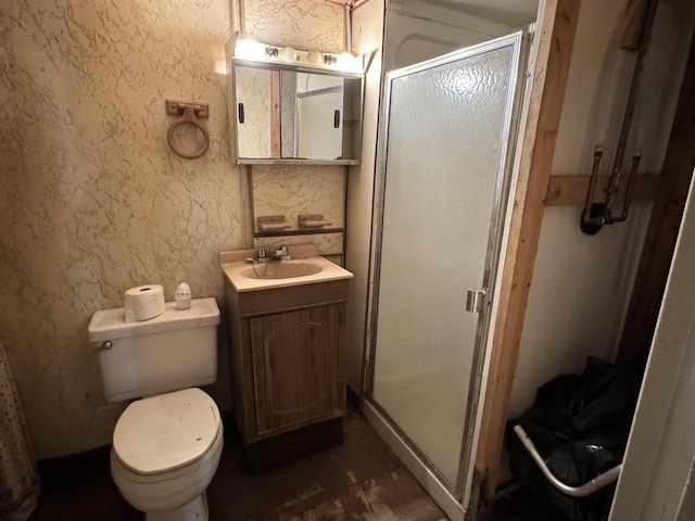 bathroom with a shower with door, vanity, and toilet