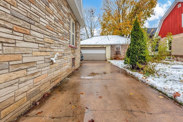 snow covered property with an outbuilding and a garage