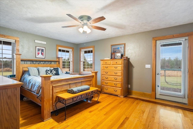 bedroom featuring ceiling fan, light hardwood / wood-style floors, and a textured ceiling