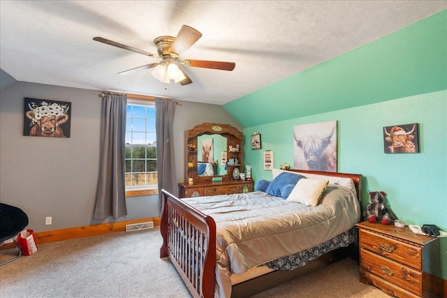 bedroom featuring a textured ceiling, light colored carpet, vaulted ceiling, and ceiling fan