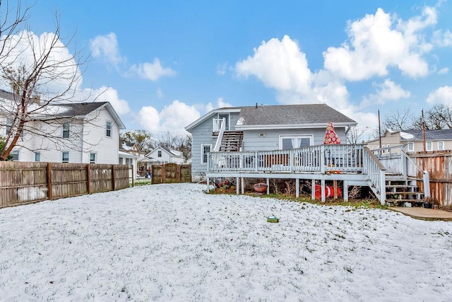 snow covered rear of property featuring a deck