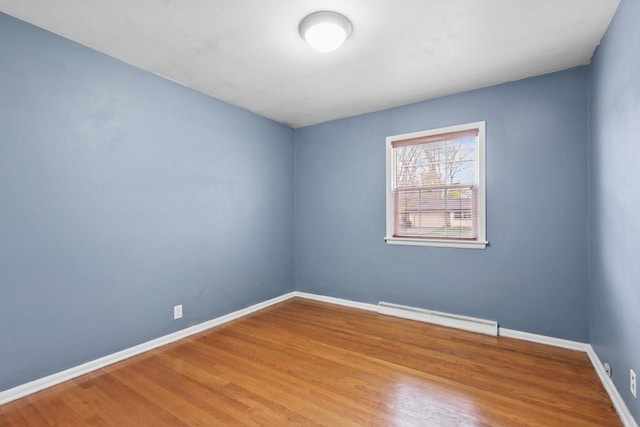 spare room with hardwood / wood-style floors and baseboard heating