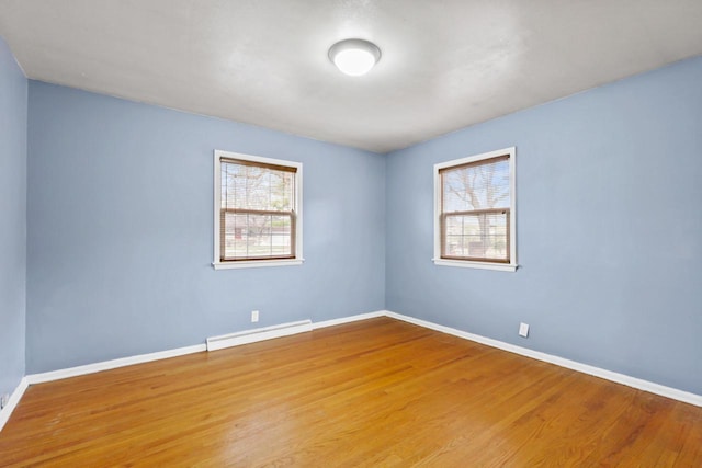 unfurnished room with hardwood / wood-style floors and baseboard heating