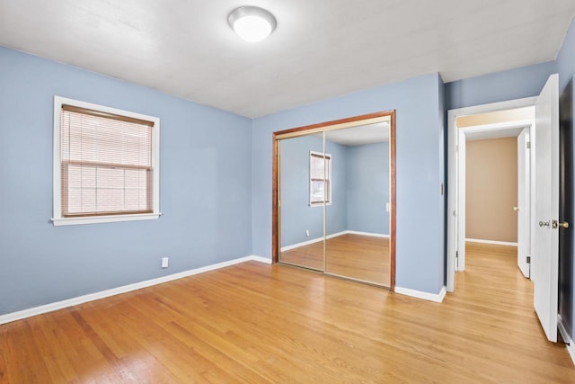 unfurnished bedroom featuring light wood-type flooring and a closet