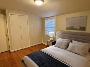 bedroom featuring dark hardwood / wood-style flooring, lofted ceiling, and a closet