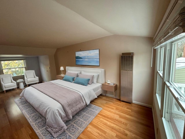 bedroom with light wood-type flooring and lofted ceiling