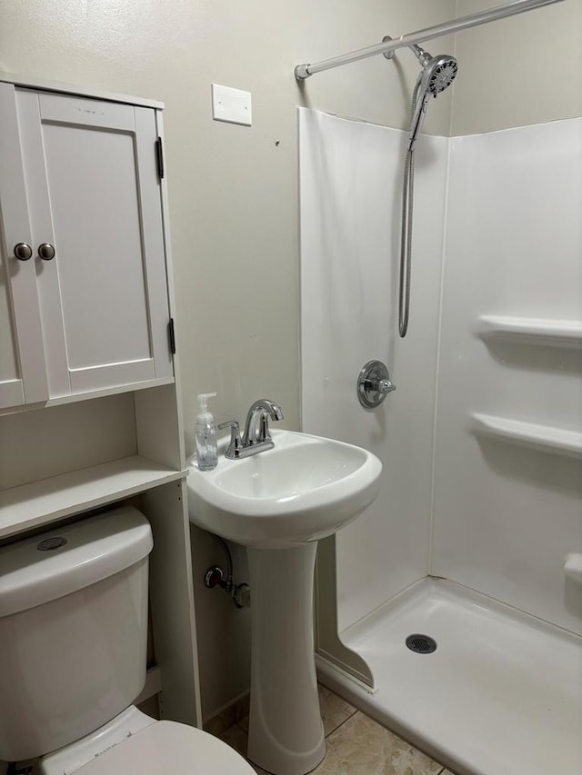 bathroom with tile patterned floors, toilet, and walk in shower