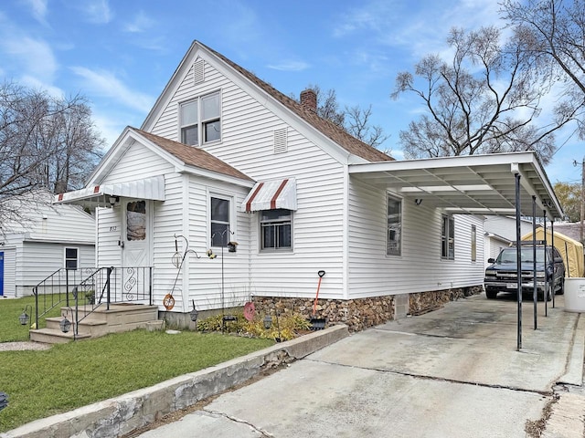 view of side of property with a lawn and a carport