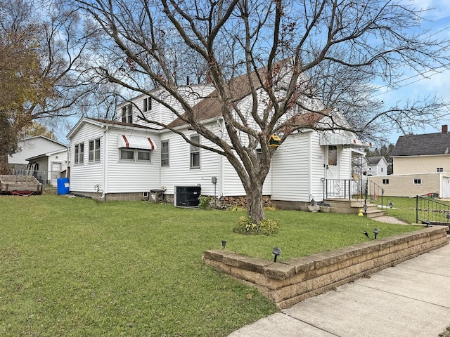 view of side of home with a yard and central AC unit