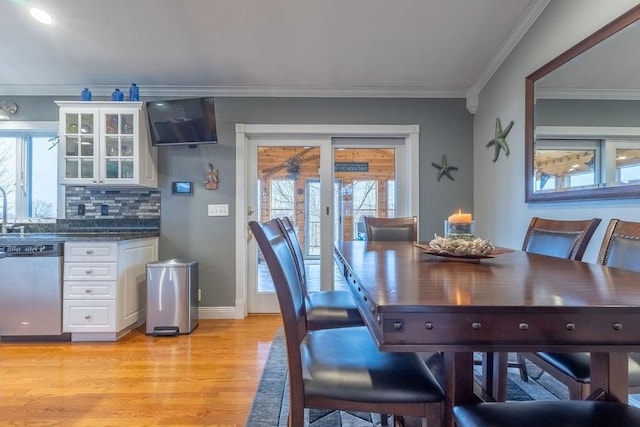 dining space featuring light hardwood / wood-style floors, a wealth of natural light, and ornamental molding