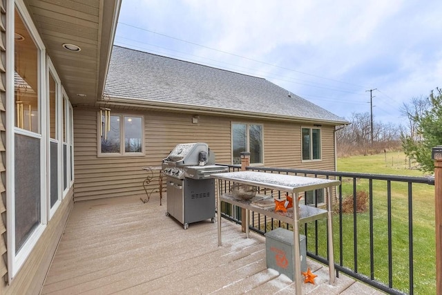 wooden deck featuring grilling area and a lawn