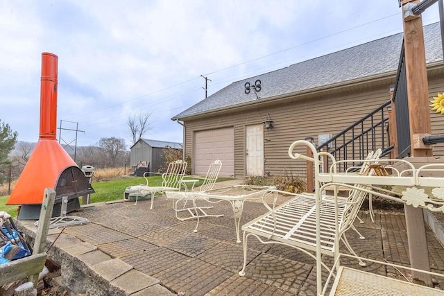 view of patio with an outbuilding and a garage