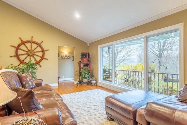 living room featuring hardwood / wood-style flooring, vaulted ceiling, and crown molding