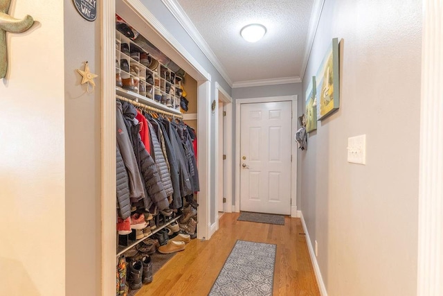 mudroom featuring ornamental molding, a textured ceiling, and light hardwood / wood-style flooring