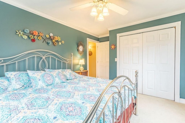 carpeted bedroom with ceiling fan, ornamental molding, and a closet