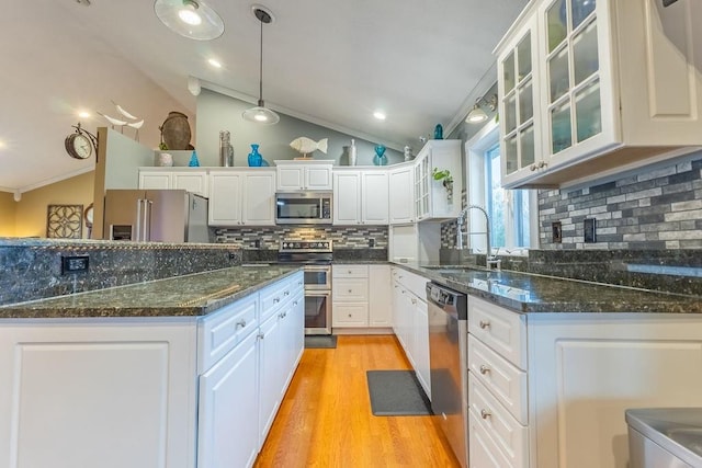 kitchen featuring white cabinets, sink, stainless steel appliances, and vaulted ceiling