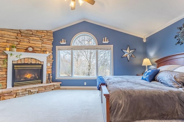 bedroom with ornamental molding, vaulted ceiling, ceiling fan, a fireplace, and carpet floors