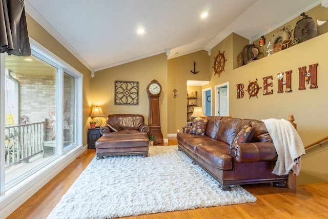 living room with ornamental molding, lofted ceiling, and light wood-type flooring