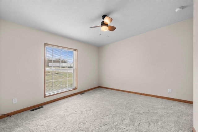 empty room featuring carpet, ceiling fan, and a textured ceiling