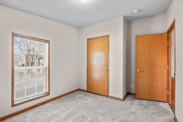 unfurnished bedroom with light colored carpet and a textured ceiling