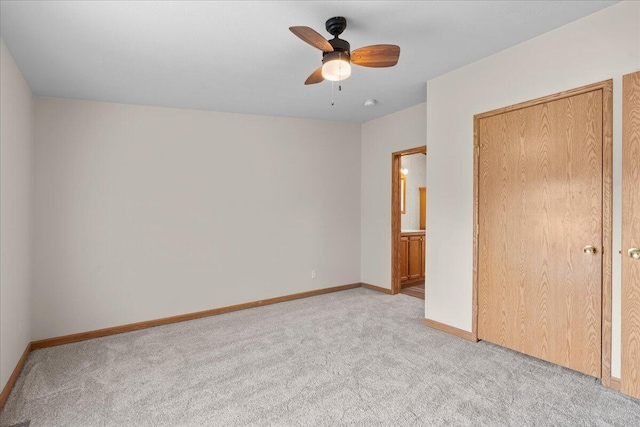 unfurnished bedroom featuring light carpet, a closet, and ceiling fan