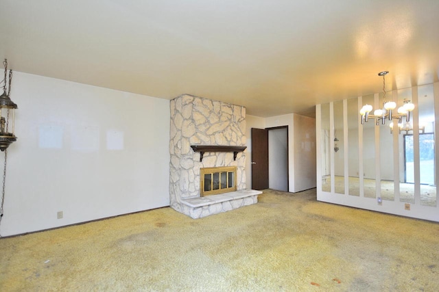 unfurnished living room with carpet flooring, a stone fireplace, and a chandelier