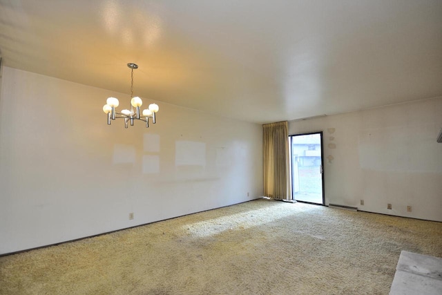 carpeted empty room with a chandelier